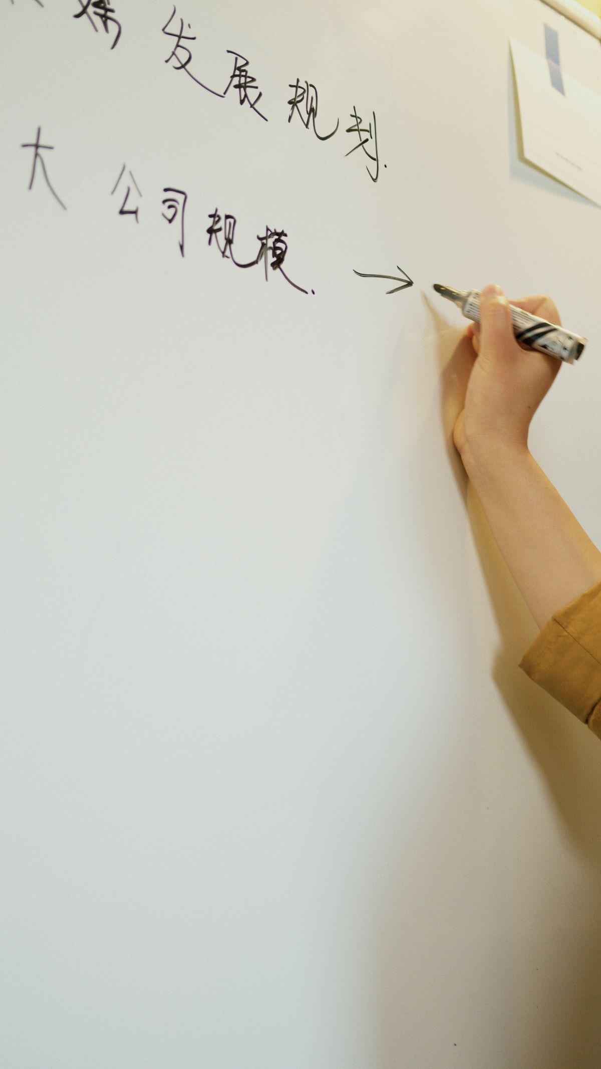 ホワイトボードに予定を手書きする様子